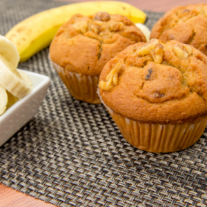 trio of banana muffins with sliced bananas on placemat