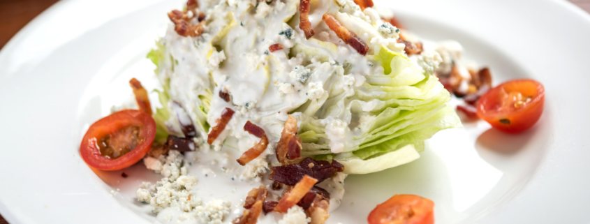 blue cheese wedge salad with salad dressing tomatoes bacon crumbles