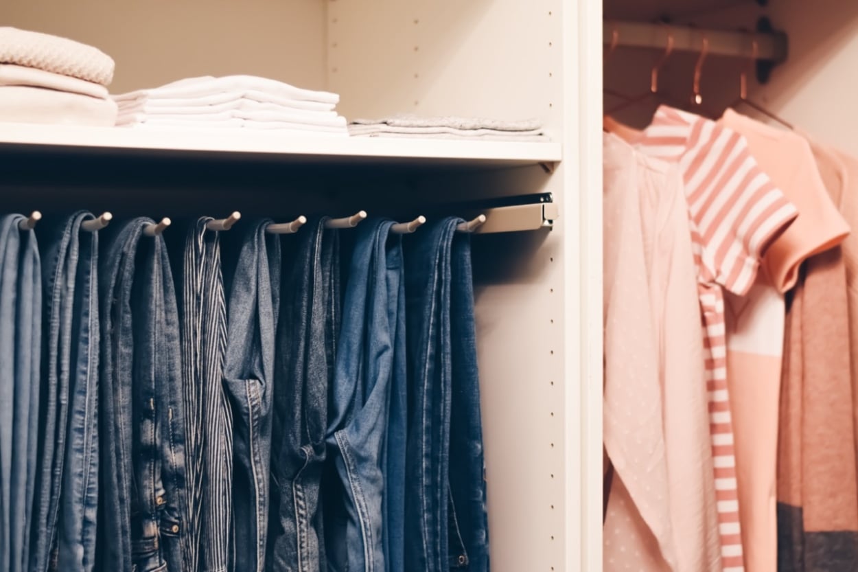 how to organize a closet jeans hanging and blush colored tops