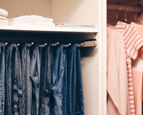 how to organize a closet jeans hanging and blush colored tops
