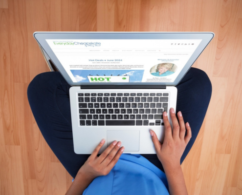 hot deals june 2024 woman with blue shirt on laptop sitting cross legged