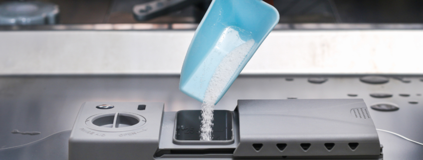DIY Homemade dishwasher detergent hand scooping into dispenser