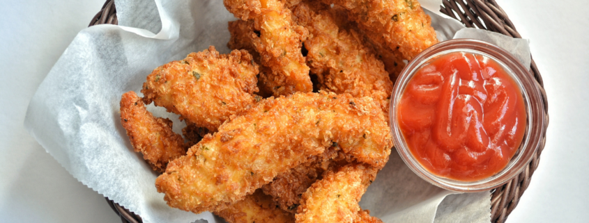 homemade shake and bake chicken breast tenders in basket with sauce