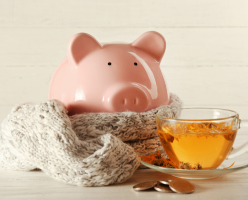piggy bank wearing scarf coins and hot tea winterize your home diy cut lower heating costs