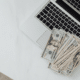 Twenty dollar bills sitting on macbook laptop