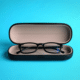 repurpose old eyeglasses cases on blue background with reading glasses