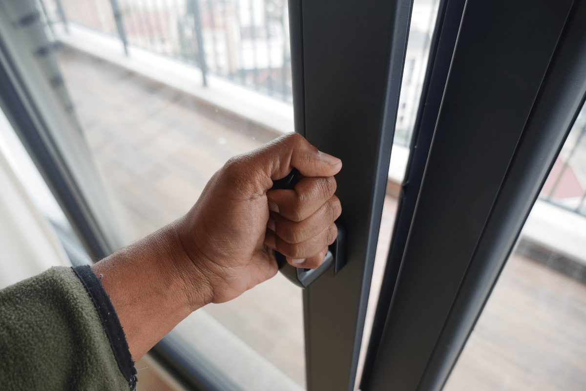 male hand closing a sliding glass door