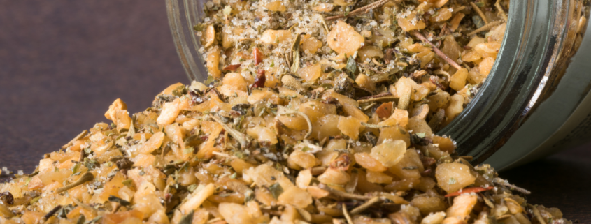 homemade garlic seasoning blend pouring out of glass jar
