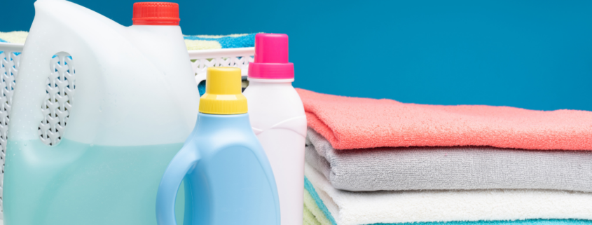 homemade liquid laundry detergent diy borax washing soda ash dawn ultra stack of towels basket on blue background