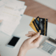 credit card debt questions woman holding bills with iphone and calculator in background