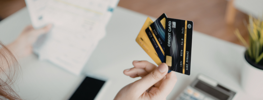 credit card debt questions woman holding bills with iphone and calculator in background