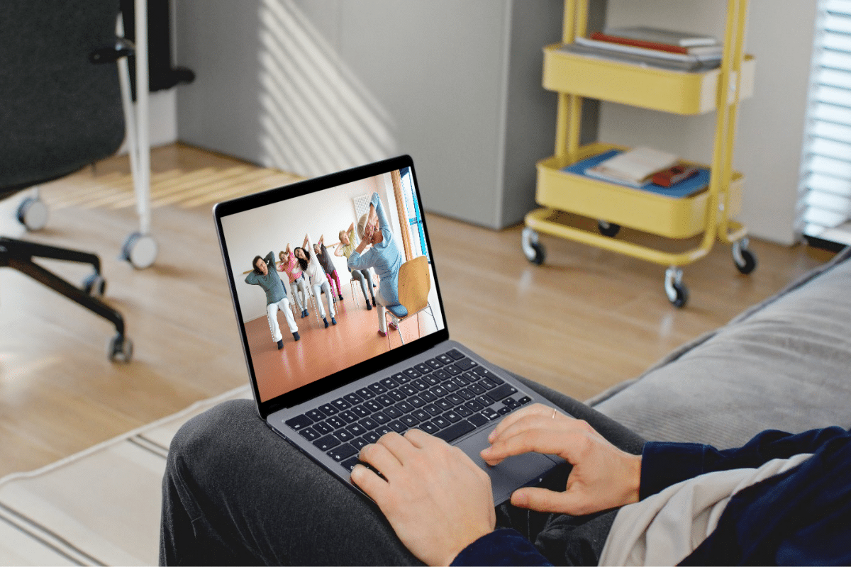 man on laptop watching a free chair yoga youtube video on a laptop