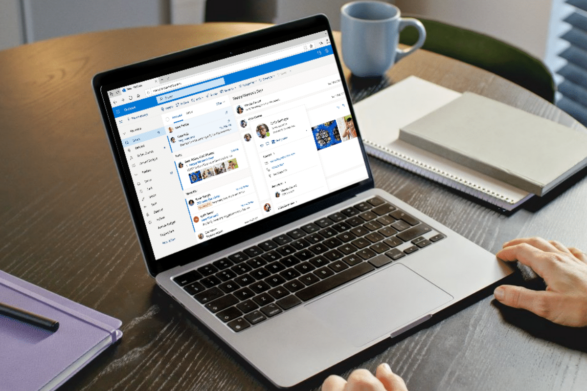 how to safelist an email address in outlook email provider laptop on round table with man's hands and notebooks
