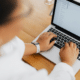 woman typing on laptop keyboard learning how to safelist an email address.