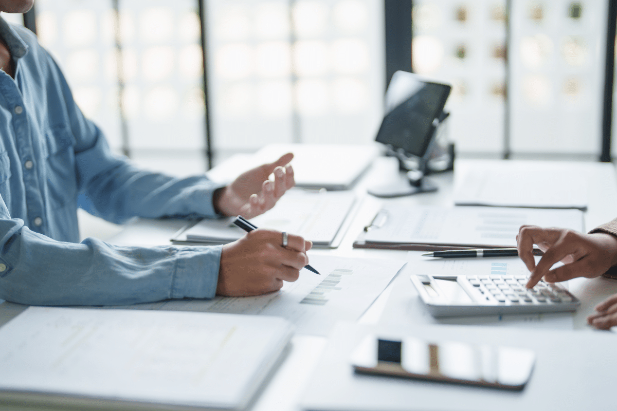 tax preparer sitting with client at desk with calculator