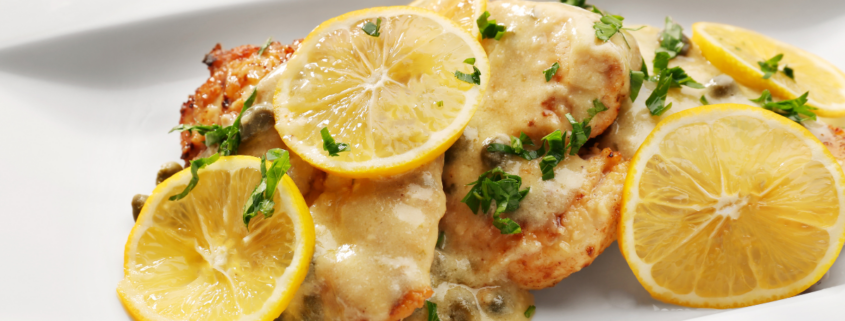 creamy lemon garlic chicken recipe in white plate lemon slices fresh basil