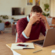 man with head in hands sitting at laptop how to survive an income crisis job loss