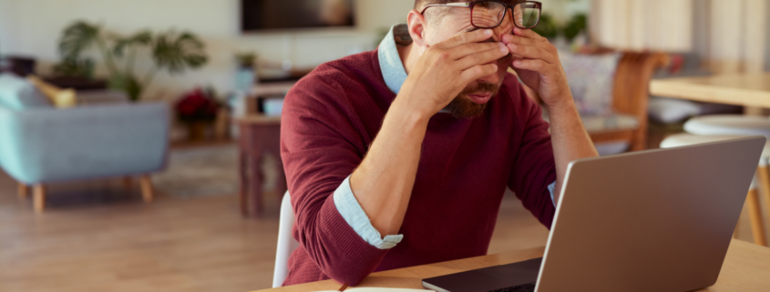 man with head in hands sitting at laptop how to survive an income crisis job loss