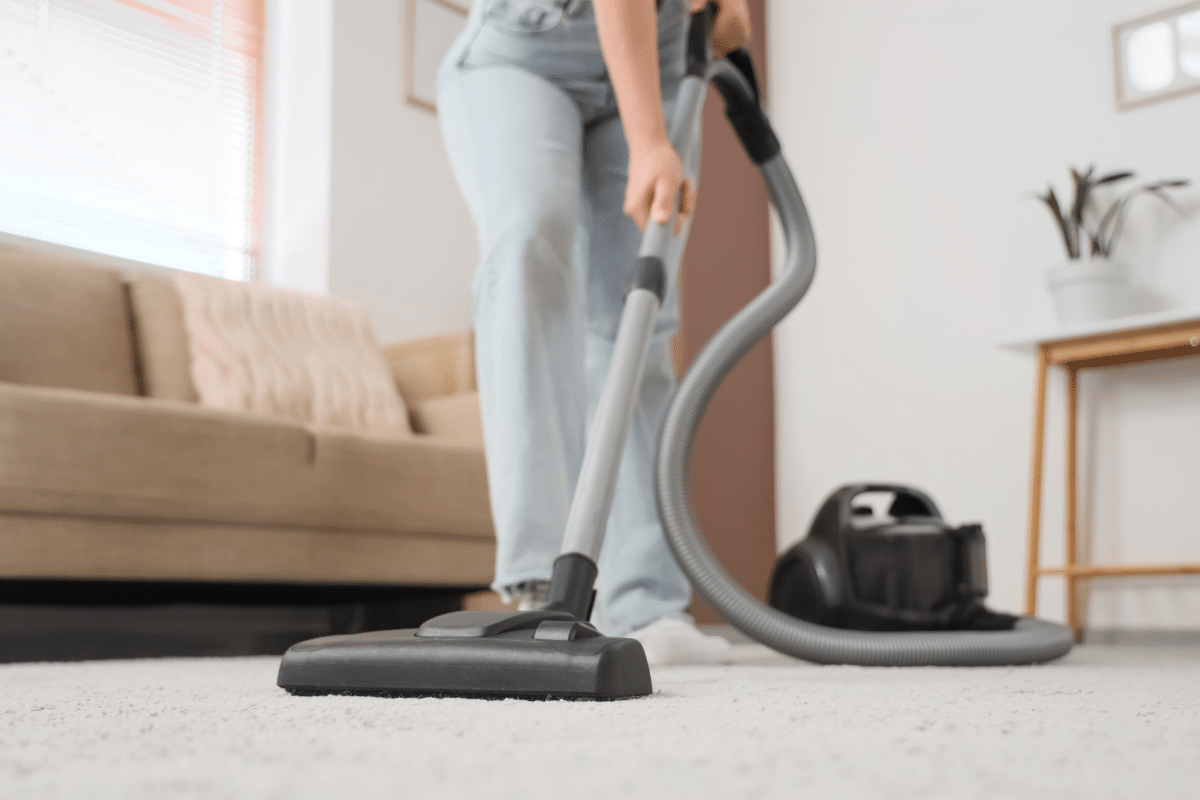 sweep or vacuum high traffic areas living room woman tidying friday reset routine