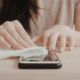 woman disinfecting iphone how to clean phone