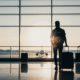 smart travel tips father and daughter standing in airport watching an airplane land