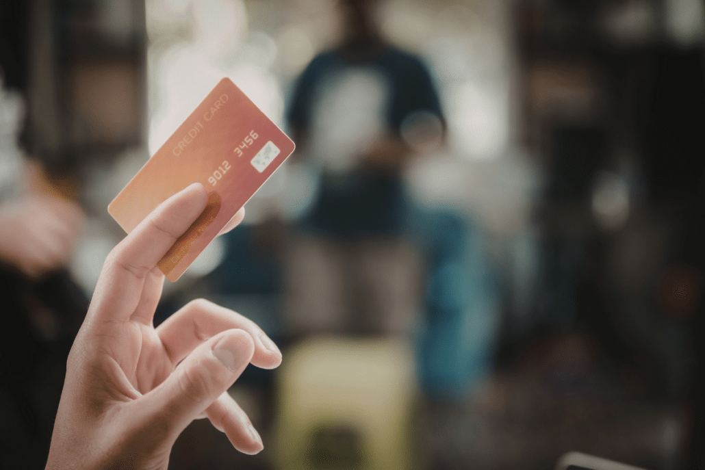hand holding an orange credit card up opt out of credit card interest rate increase