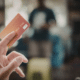 hand holding an orange credit card up opt out of credit card interest rate increase