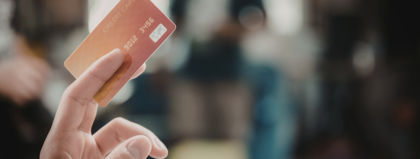 hand holding an orange credit card up opt out of credit card interest rate increase