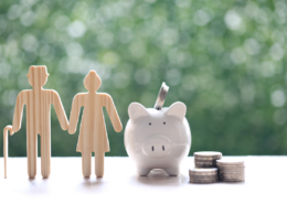borrowing from your retirement account piggy bank and wood cutout of retired couple