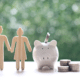 borrowing from your retirement account piggy bank and wood cutout of retired couple