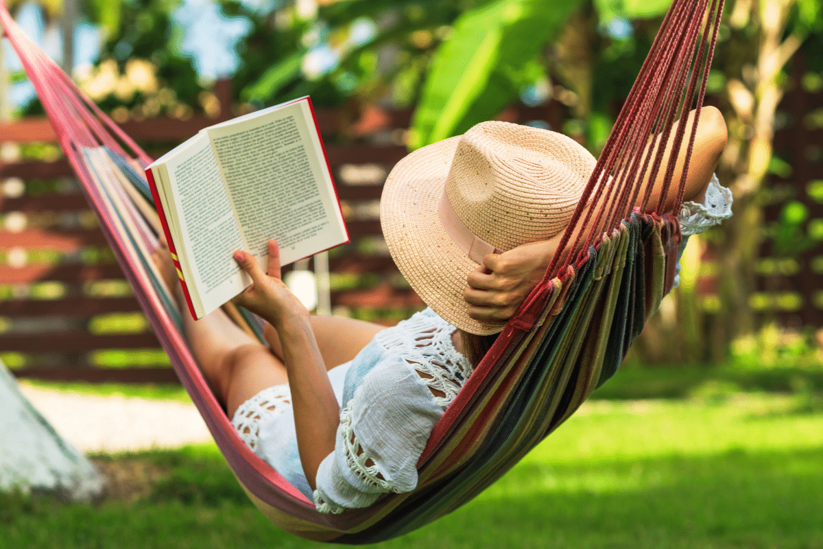 woman relaxing and reading in hammock