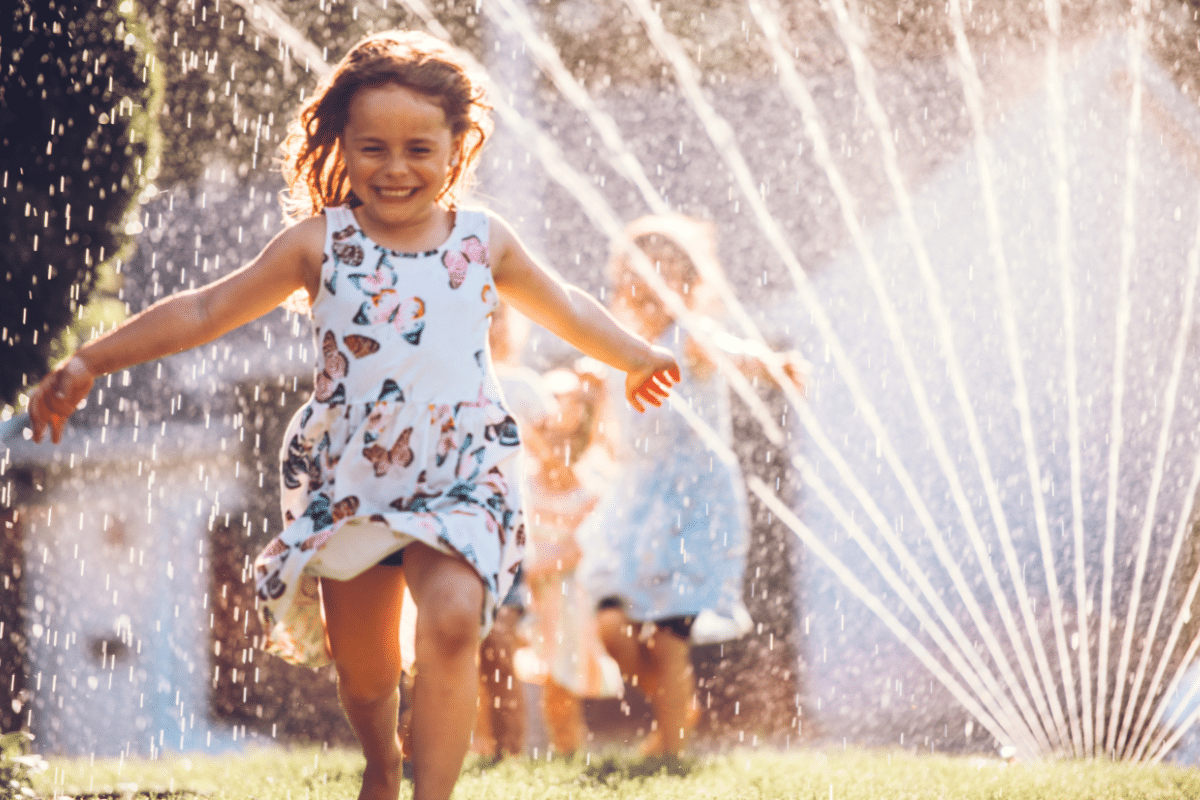 Free Summer Activities for Kids Who Are So Bored little girl running through the sprinklers