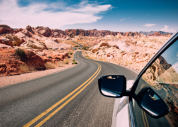 road trip car checklist car driving through the desert winding road with blue skies
