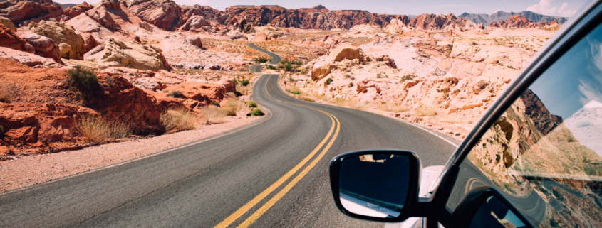 road trip car checklist car driving through the desert winding road with blue skies