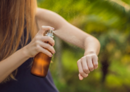 woman using an amber glass DIY mosquito repellent spray
