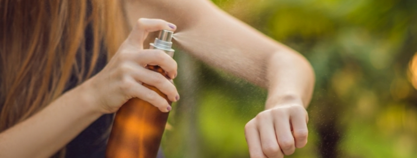 woman using an amber glass DIY mosquito repellent spray