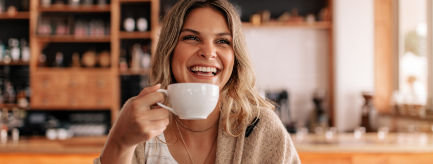 how to splurge on a budget woman drinking fancy coffee luxury treat smiling