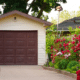 a single car garaged with beautiful flowers along landscape beds things ruined by heat in the garage