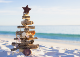 a rustic wooden christmas tree in the sand on the beach