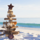 a rustic wooden christmas tree in the sand on the beach