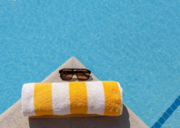 best inexpensive beach towel with sunglasses on edge of swimming poo