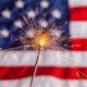 a lit sparkler with an american flag in the background 4th of july hacks tips and recipes
