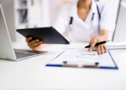 negotiate medical bills female nurse with calculator and ipad negotiating a bill