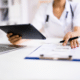 negotiate medical bills female nurse with calculator and ipad negotiating a bill