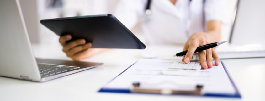 negotiate medical bills female nurse with calculator and ipad negotiating a bill