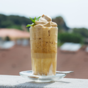 creamy whipped frozen coffee drink on balcony with whipped cream