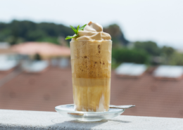 creamy whipped frozen coffee drink on balcony with whipped cream