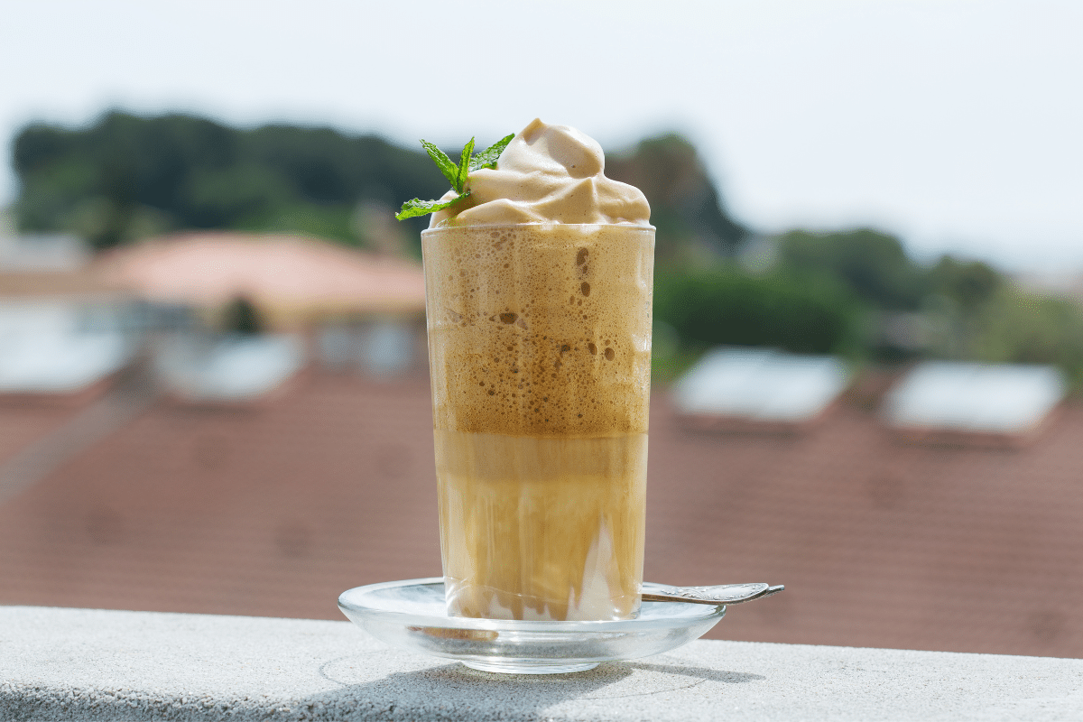 creamy whipped frozen coffee drink on balcony with whipped cream