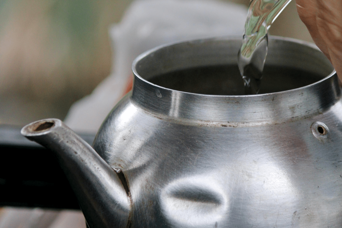 stovetop iced tea pouring water into metal kettle