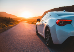 luxury car driving down mountain highway how to lower car insurance premium